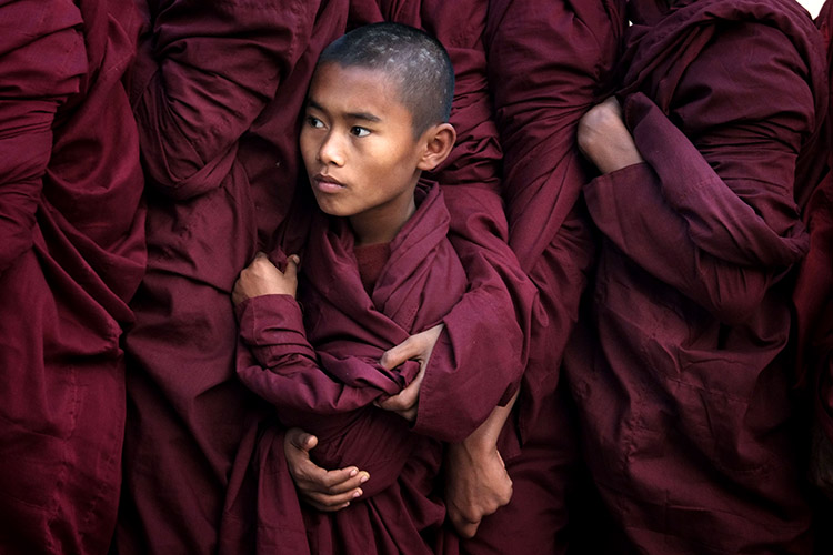 Myanmar, Bagan, © Alain Schroeder At 7AM during the annual festival of Ananda Pagoda in Bagan, monks line up to receive alms prepared by devotees who have journeyed from all corners of the country. A young monk finds himself stuck in between his brothers in the shuffle.